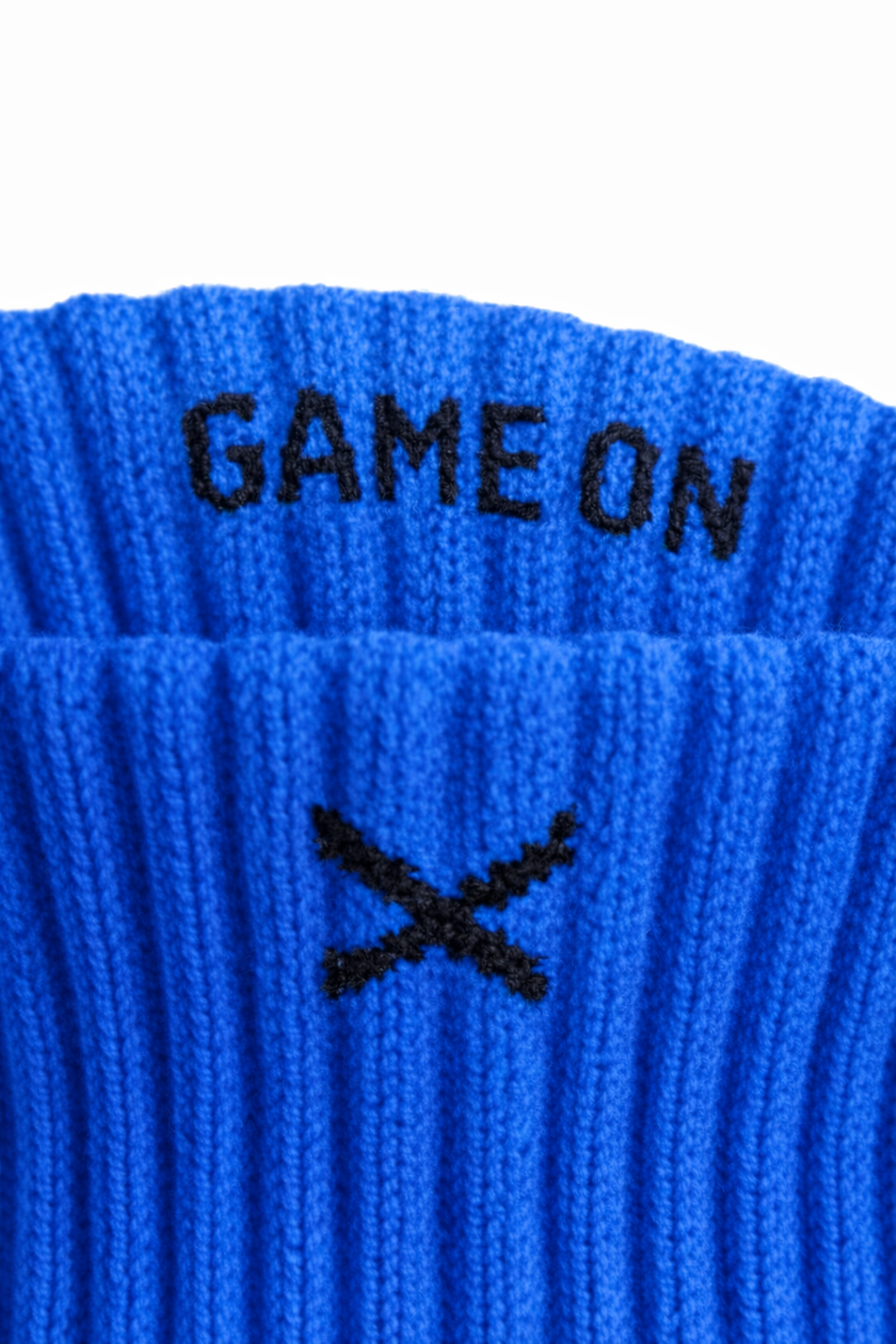 Close-up av blå EliteX™ Gripsokker – Blå med tekst "GAME ON" og svart logo, designet for optimalt grep og komfort under fotballspill.