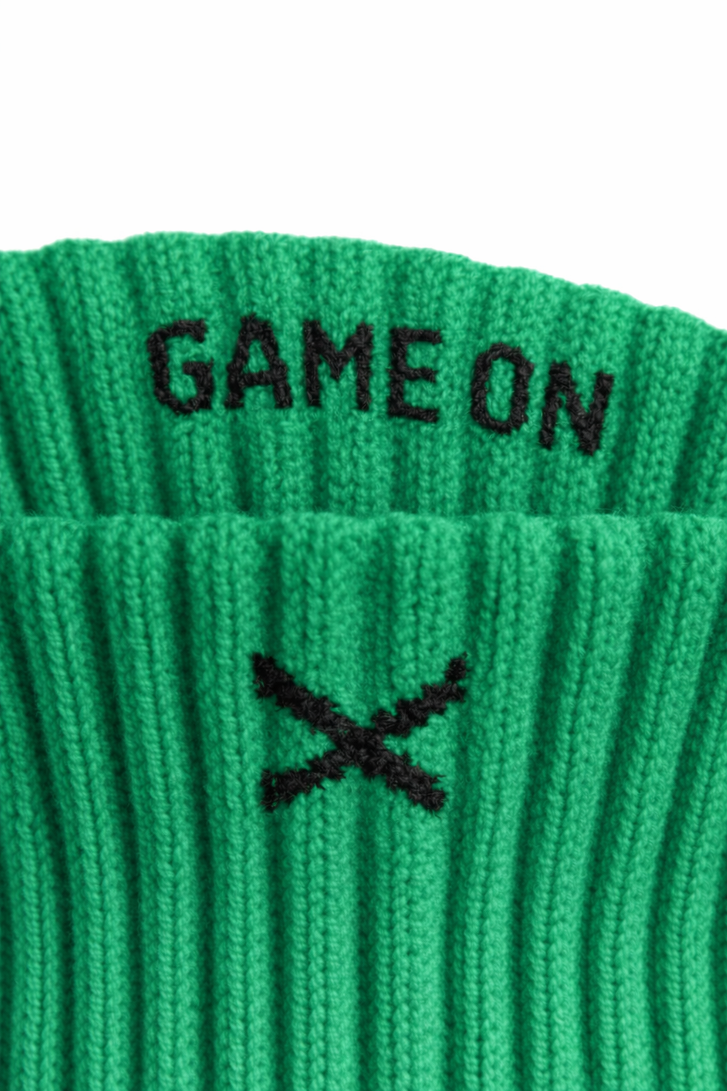 Nærbilde av EliteX™ Gripsokker – Grønn med tekst "GAME ON" og logo i sort på ribbestrikket stoff i levende grønnfarge.
